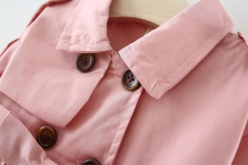 Baby girl's stylish pink trench coat with belt and buttons – perfect autumn and winter outerwear.