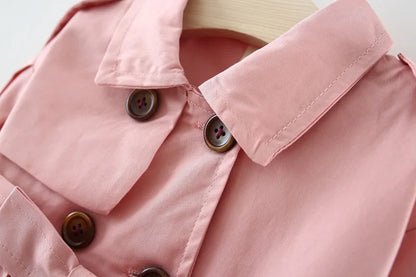 Baby girl's stylish pink trench coat with belt and buttons – perfect autumn and winter outerwear.