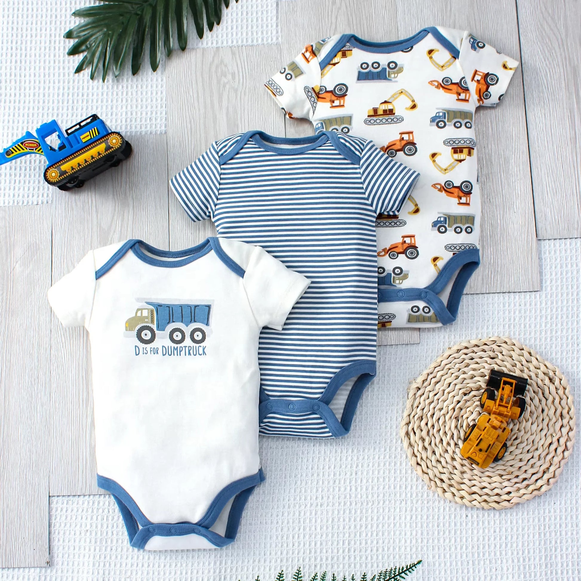 Set of three dump truck baby bodysuits – soft cotton onesies with playful truck prints