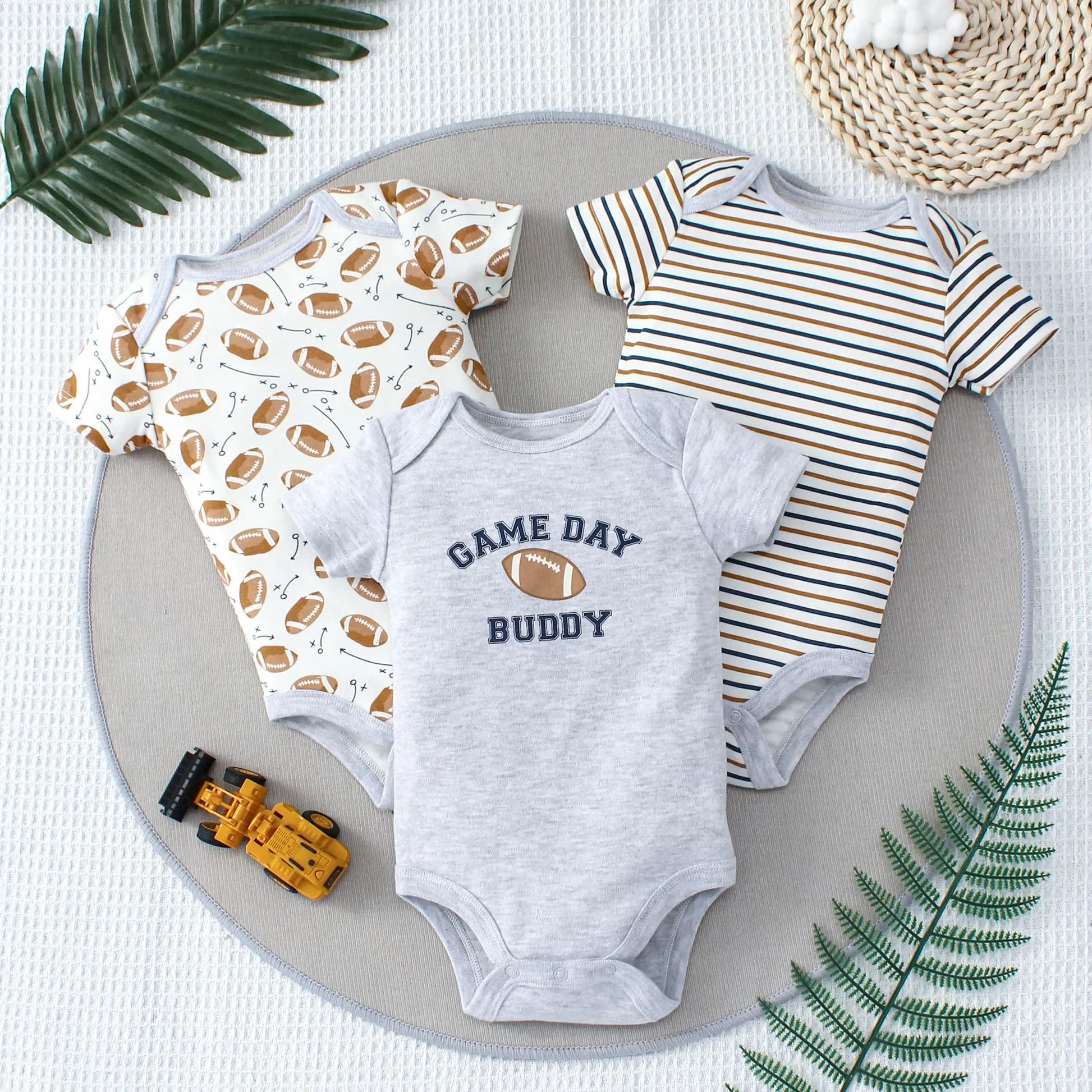 Set of three game day baby bodysuits with playful sports-themed prints
